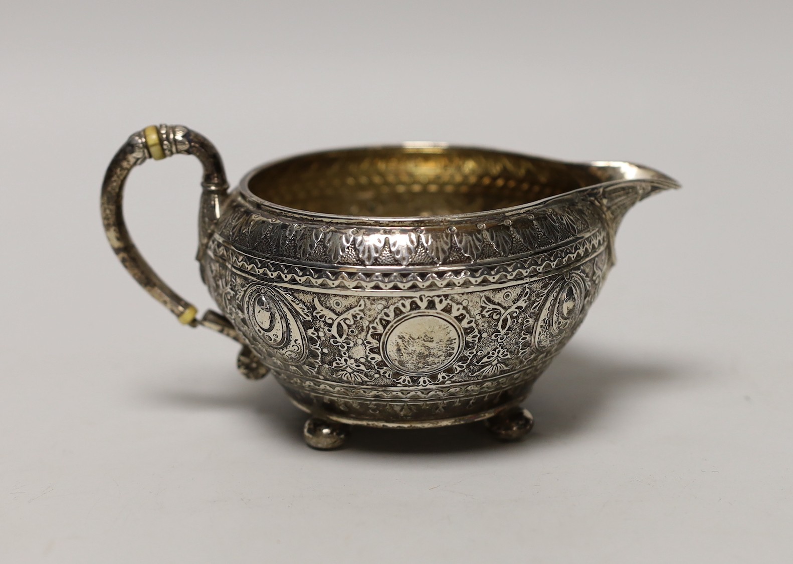 A late Victorian embossed silver cream jug, by Walter & John Barnard, London, 1893, height 74mm, gross weight 5oz.